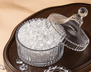 Detail view of clear white crystal stones in an elegant ribbed glass bowl for purification.