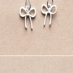 Close-up detail of S925 sterling silver matte bow pendants for DIY jewelry making crafts