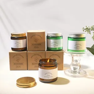 Collection of soy wax scented candles in amber and green glass jars with boxes