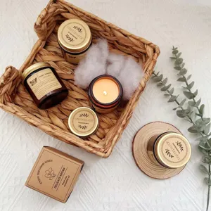 Top-down view of amber glass jar candles with gold lids nested in a woven basket setup.
