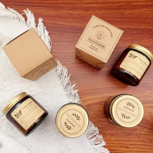Close-up of brown glass jar scented candles and kraft gift boxes on a wooden background