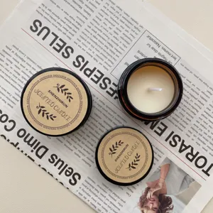 Detail view of mini 35g soy wax scented candles in amber glass jars on newspaper