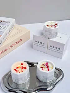 Detailed view of handmade soy wax candles in marble gypsum cups with gift boxes