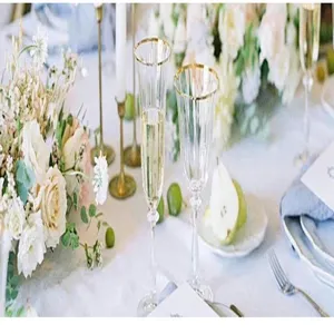 Elegant long white taper candles in vintage gold holders at romantic wedding table setup