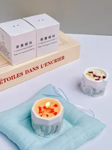 Close-up of handmade soy wax scented candle in marble gypsum cup with gift packaging