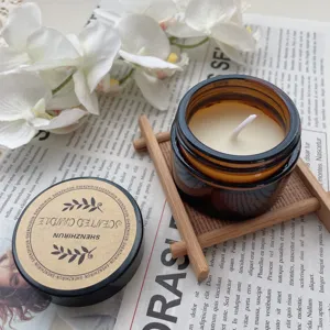 Macro view of a 35g soy wax scented candle in a brown glass jar with a wooden stand.