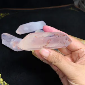 Gros plan détaillé d'une pointe de cristal de quartz blanc naturel tenue dans la main