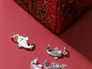 Macro detail of S925 sterling silver vintage koi fish charms for DIY jewelry making.