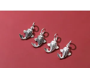 Detail of four vintage S925 sterling silver koi fish pendants for DIY jewelry making.