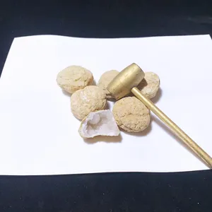 Vue rapprochée de géodes naturelles de cristal blanc du Maroc avec un petit marteau en or