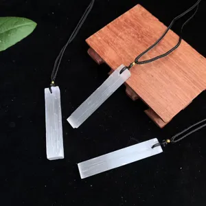 Close-up of three natural translucent selenite stone bar pendants with black cord