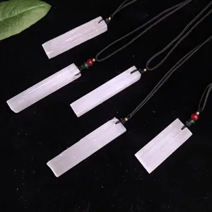Detailed macro view of natural white selenite rectangular stone pendants with black cords