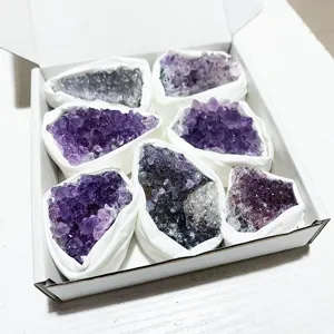 Vue détaillée de grappes d'améthyste naturelle d'Uruguay dans une boîte cadeau blanche