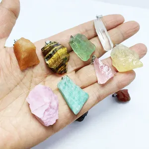Sortiment an natürlichen Rohkristallstein-Anhängern für DIY-Schmuck in der Hand