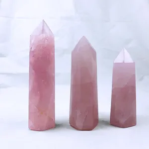 Set of three natural rose quartz hexagonal crystal pillars in varying heights for decor