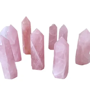 Multiple natural rose quartz hexagonal crystal pillars standing on a clean white background