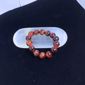 Bracelet œil de tigre rouge sur une plaque de purification en sélénite blanche