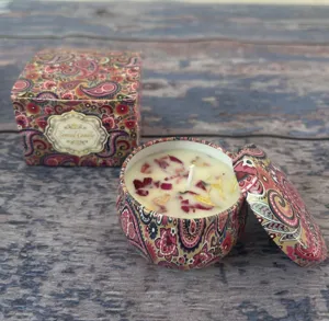 Dettaglio di una candela profumata alla soia con fiori secchi in una scatola paisley