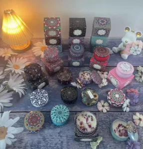 Vista dettagliata di candele in cera di soia con motivi mandala e petali di fiori secchi