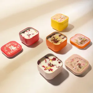 Assorted scented candles in colorful illustrated tins with dried petals
