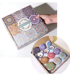 Set of 12 mandala scented candles in a decorative gift box with soy wax and petals.