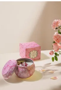 Detailed view of a pink soy wax scented candle with dried flowers and rose packaging