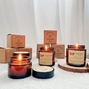 Warm scented soy wax candles lit in amber glass jars with Kraft paper gift boxes