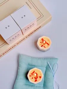 Detailed view of scented soy wax candles in octagonal gypsum cups with elegant packaging