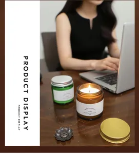 Detailed lifestyle view of a scented soy wax candle in an amber glass jar on a wooden desk
