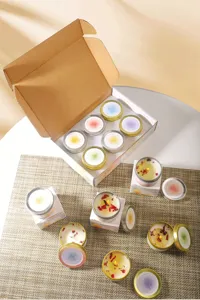 Detailed view of aromatic soy candles with dried flower petals and a gift box set.