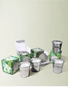 Primer plano de velas de citronela en cubos metálicos con cajas de estampado