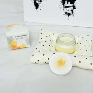 Nahaufnahme einer Duftkerze aus Sojawachs mit Geschenkbox, Birne und Freesie