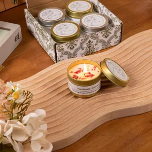 Set regalo di candele profumate in cera di soia con fiori secchi su vassoio in legno.