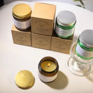 Premium scented soy wax candles in amber and green glass jars with minimalist kraft gift boxes