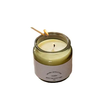 Hand-poured aromatic soy wax scented candle in a brown glass jar being lit by a match