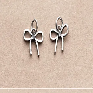 Macro detail of vintage matte S925 silver bow pendant charms for DIY jewelry making