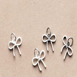 Detail view of matte S925 sterling silver bow pendants for DIY jewelry making