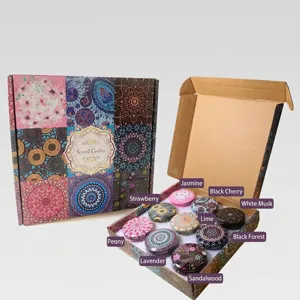 Vista detallada del set de regalo de 9 velas aromáticas con latas decorativas.