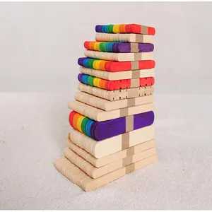 Close-up of stacked natural and rainbow colored wooden popsicle sticks for DIY crafts