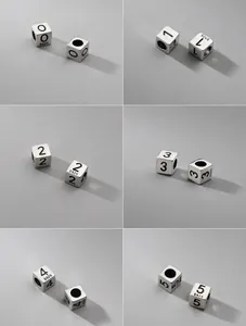 Detalle macro de cuentas espaciadoras de cubo en plata S925 con números grabados