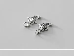 Close-up of vintage S925 sterling silver koi fish charms for DIY jewelry making.