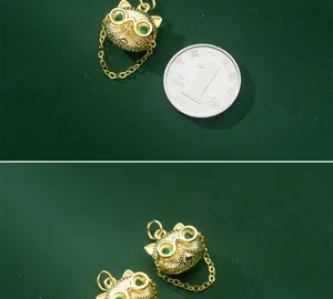 Gros plan d'un pendentif chat hip-hop doré avec des yeux en pierre verte.