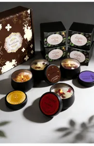 Gros plan de diverses bougies parfumées en boîtes noires avec emballages cadeaux élégants