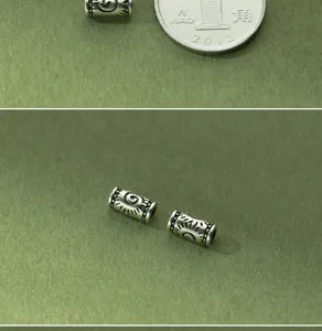 Close-up of S925 Thai silver vintage 4mm spacer beads with engraved sun patterns.