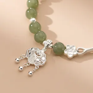 Primo piano del bracciale in argento con lucchetto della pace e perle di giada verde