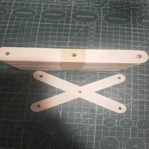 Detail of natural wooden craft sticks with pre-drilled holes on a grid cutting mat