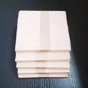 Detailed view of bundled natural wood popsicle sticks stacked on dark surface