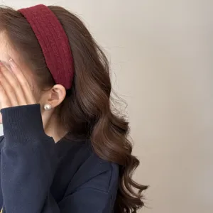 Gros plan d'un bandeau large en tricot bordeaux montrant la texture sur cheveux