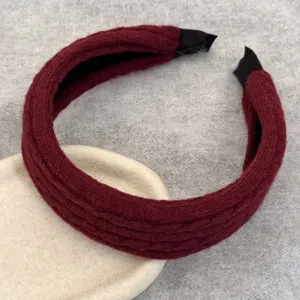 Détail rapproché d'un serre-tête en tricot bordeaux pour la mode d'hiver et la coiffure.