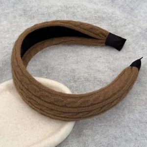 Vue détaillée d'un serre-tête marron en maille torsadée montrant la texture et la finition